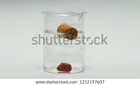 materials with different density, one stopper floats and another goes down
