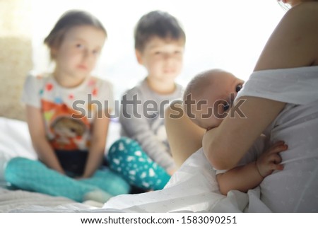 Similar – Relaxed mother and sons playing over the bed