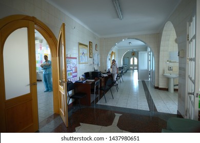 At The Maternity Department. Doctor Holding A Newborn Baby Visible Through Opened Door, Nurse Sitting In A Nurse’s Station. June 25, 2019. Kiev, Ukraine  