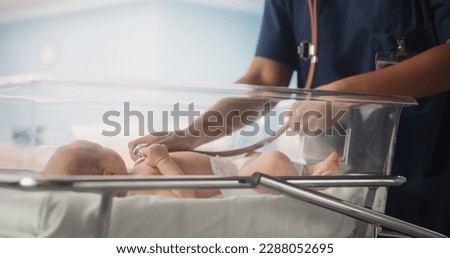 Maternity Hospital Ward: Friendly Black Head Nurse Uses Stethoscope to Listen to Heartbeat and Lungs of Recovering Newborn Baby Resting in Bed. African Pediatrician Does Checkup in Nursery