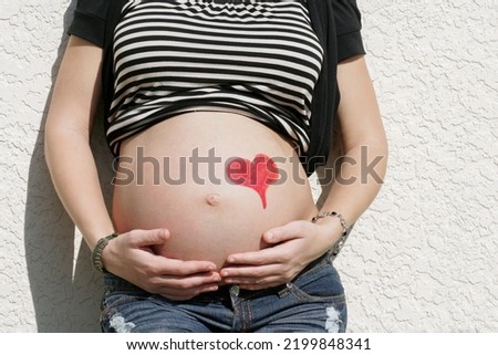 Maternity photo of a young pregnant teen woman with her hands holding her belly in love before placing her baby for adoption Stock photo © 