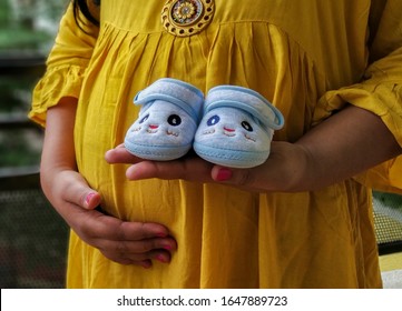 Maternity Photoshoot Of An Indian Woman With Props Of Baby Shower