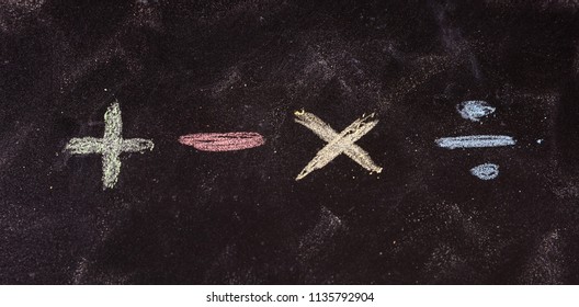 Math concept. Basic mathematical symbols written with colorful chalks, isolated, on blackboard background