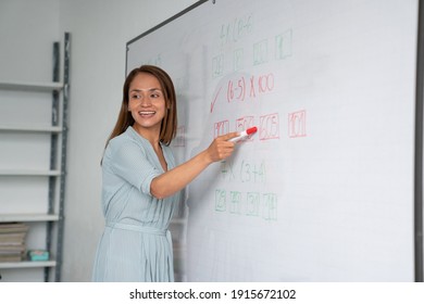 Math educator asking students and pointing to exercise on the whiteboard - Powered by Shutterstock