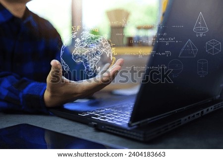 Math and physics equation concept with student hand holding globe with quotations function of geometric and law of motion in front of laptop screen on desktop