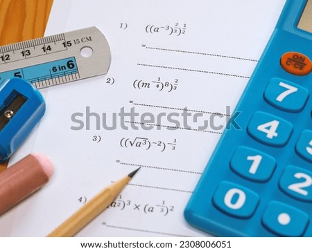 math problems worksheet with stationery on desk in classroom