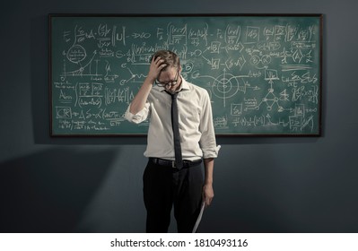 Math Student Standing In Front Of The Chalkboard And Feeling Confused, He Is Not Able To Solve The Problem