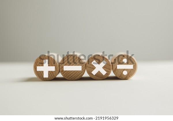 mathematic concept.,White color of\
mathematical operations or Plus, minus, multiply, divide symbols on\
wooden circle shape over white\
background.