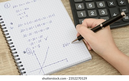 Mathematical equation and graphs in a notebook, doing homework - Powered by Shutterstock - Get 15% off with code: PIKWIZARD15