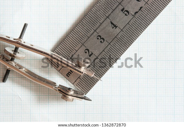 Mathematical\
instruments over the corner of a math graph paper with copy space\
for text. Math graphic tools\
concept
