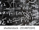 Mathematical operations and quantum physics formulas handwritten with a chalk on the blackboard