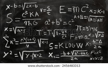 Mathematical operations and quantum physics formulas written with chalk on the blackboard