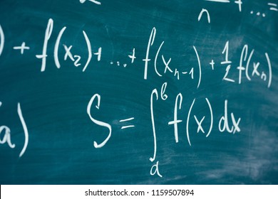 Mathematics function integra formulas written by chalk on the chalkboard.