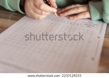 Mathematics homework.Math lesson.student is doing a math assignment.Study and education concept.schoolgirl does her homework. Close-up pencil in a childs hand writes in a notebook