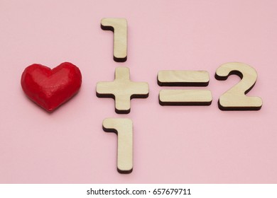 The Mathematics Of Love. One Plus One Equals Two. Pink Background.