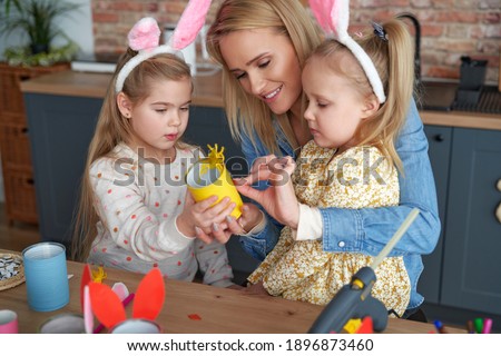 Mather and two daughter preparing Easter yellow chicken                               