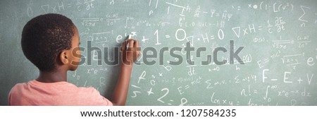 Maths against boy writing with chalk on greenboard in school