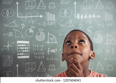 Maths against thoughtful boy against greenboard in classroom