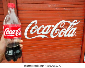 Mathura, Uttar Pradesh India- July 25 2021: Holding A Plastic Bottle Of Black Soda Cold Drink Outside The Shop. Coca Cola Is World Leader In Selling Carbonated Soda Water.