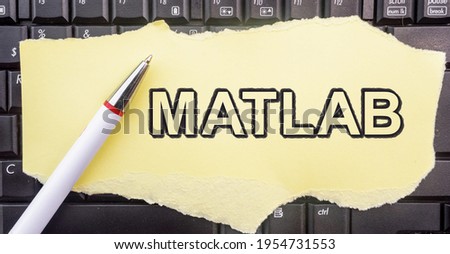 MATLAB programming language. Word Matlab on paper and laptop
