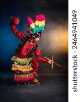 Matlachines Dancer from Coahuila Mexico A man in a colorful costume is holding a red ball and a stick. Concept of celebration and joy, as the man is participating in a cultural event or festival. 