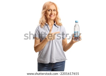 Matrue woman holding a plastic bottle of water and pointing isolated on white background