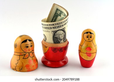 Matryoshka. Russian Doll With Dollars. Anti Crisis Money Box. Matrioska Bank. Nesting Dolls Rests On Fake Us Dollars And Russian Rubles.