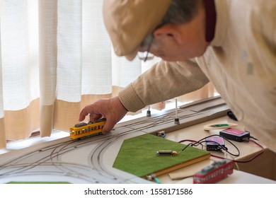 Matsudo, Chiba / Japan - November 3, 2019: An Old Man Holding Model Train On Track