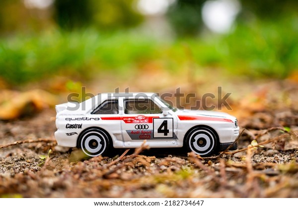 Mattel Hot Wheels white model toy Audi\
Quattro sport car with number four on the\
ground.