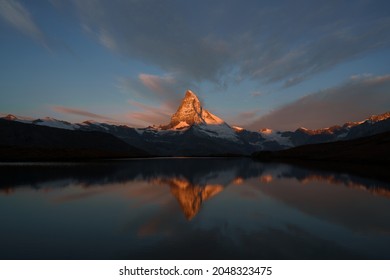 The Matterhorn (Monte Cervino) and reflection on the water surface at sunrise. Swiss mountains. Zermatt, Matterhorn