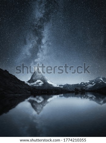 Matterhorn and reflection on the water surface at the night time. Milky way above Matterhorn, Switzerland. Travel - image