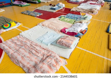mattresses on the floor in the school gym. temporary housing and accommodation for refugees during the war in Ukraine.  clean beds on the floor for refugees.