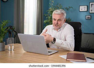 Mature 55s couple in separation talk during virtual meeting by video call. Grey haired husband enjoy conversation with wife remotely, older generation advanced users of video conference app and laptop - Powered by Shutterstock