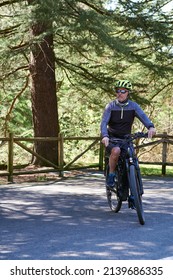 Mature 60 Year Old Man Riding A Bike Surrounded By Trees