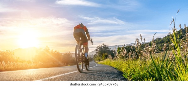 Mature Adult on a racing bike climbing the hill at mediterranean sea landscape coastal mountain road - mallorca mountains - Powered by Shutterstock