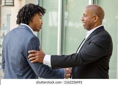 Mature African American businessman mentoring a younger man.