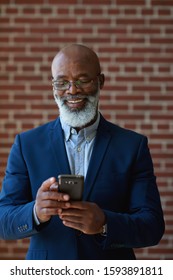Mature african american businessman using smartphone in office texting on mobile phone