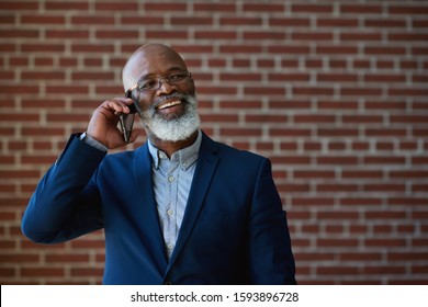 Mature african american businessman using smartphone talking having phone call conversation in office