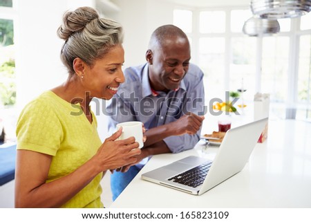Mature African American Couple Using Laptop At Breakfast
