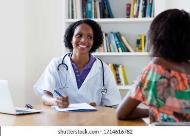 Mature African American Female Doctor Talking About Recovery To Patient At Hospital