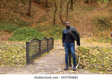 Mature African American Handsome Man Posing In Autumn Park With Copy Space For Your Text Message Or Advertising, Fashionable Male Dressed In Casual Black Dark Clothes Posing Outdoors
