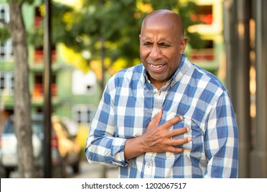 Mature African American man having chest pains. - Powered by Shutterstock