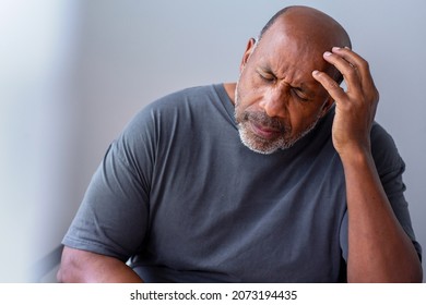 Mature African American man holding his head. - Powered by Shutterstock
