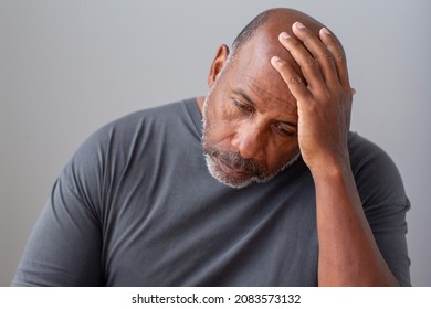 Mature African American man holding his head. - Powered by Shutterstock