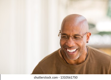 Mature African American man smiling wearing glasses.