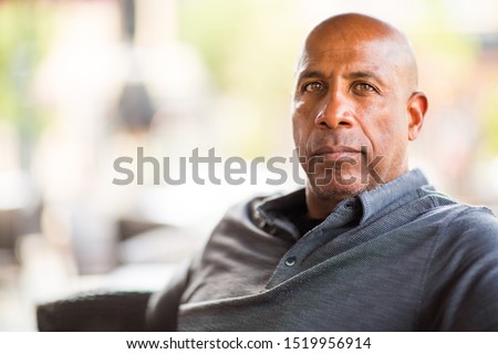 Mature African American man smiling outside.