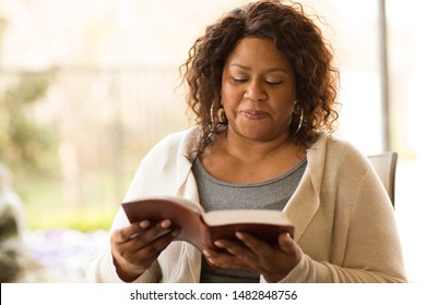 Mature African American reading The Bible. - Powered by Shutterstock