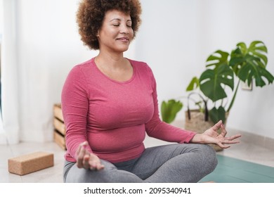 Mature African Woman Doing Yoga Meditation At Home - Healthy Lifestyle Concept