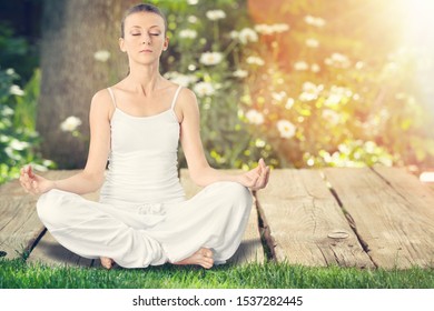 Mature African Woman Practicing Yoga And Meditates Near Swimming Pool Outdoor. Fitness Black Lady Sitting In Lotus Pose With Closed Eyes. African American Woman Meditating At Poolside With Copy Space.