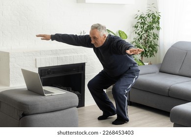 Mature aged man watching video training tutorial online, vlogging and blogging at home on lockdown - Powered by Shutterstock